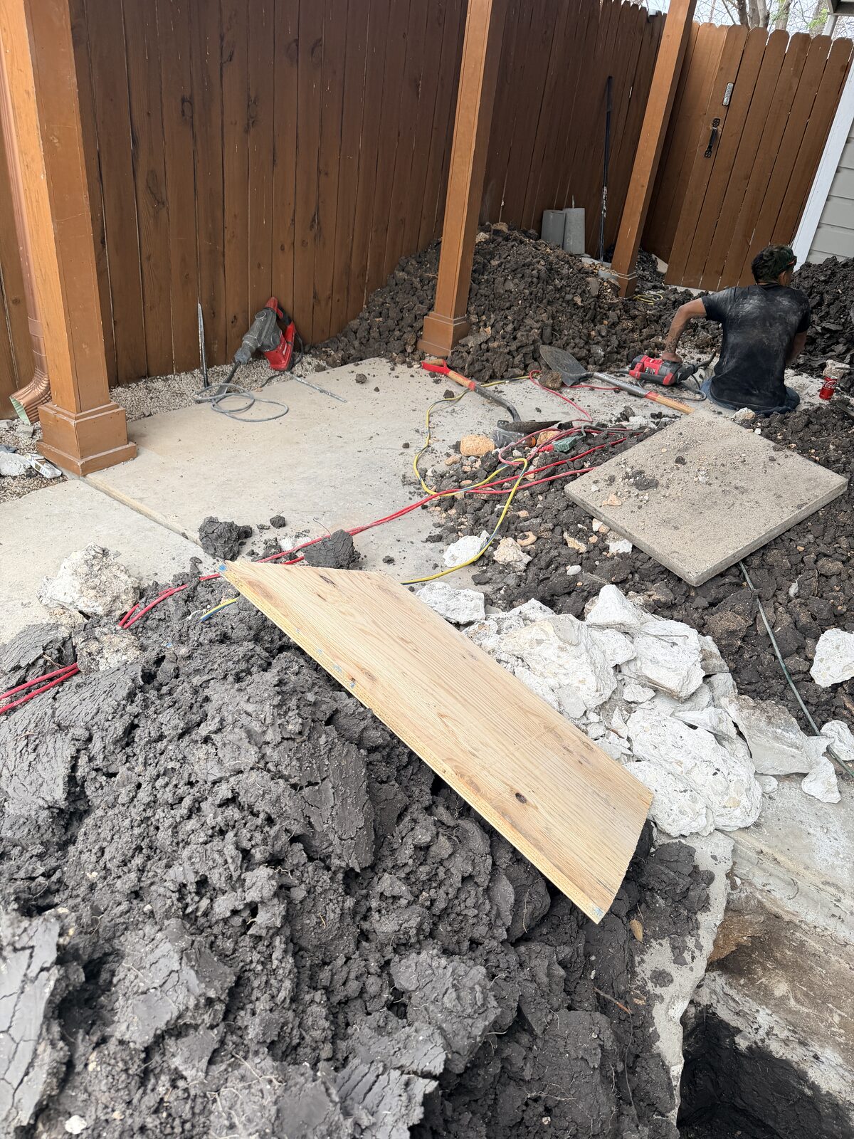 Overview of a backyard foundation pier installation in progress on a Central Texas home