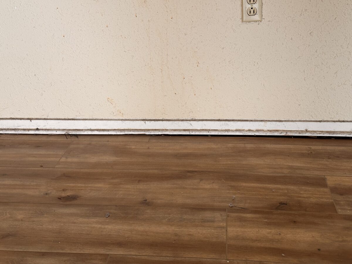 Baseboard pulling away from new vinyl plank flooring as the foundation beneath continues to settle