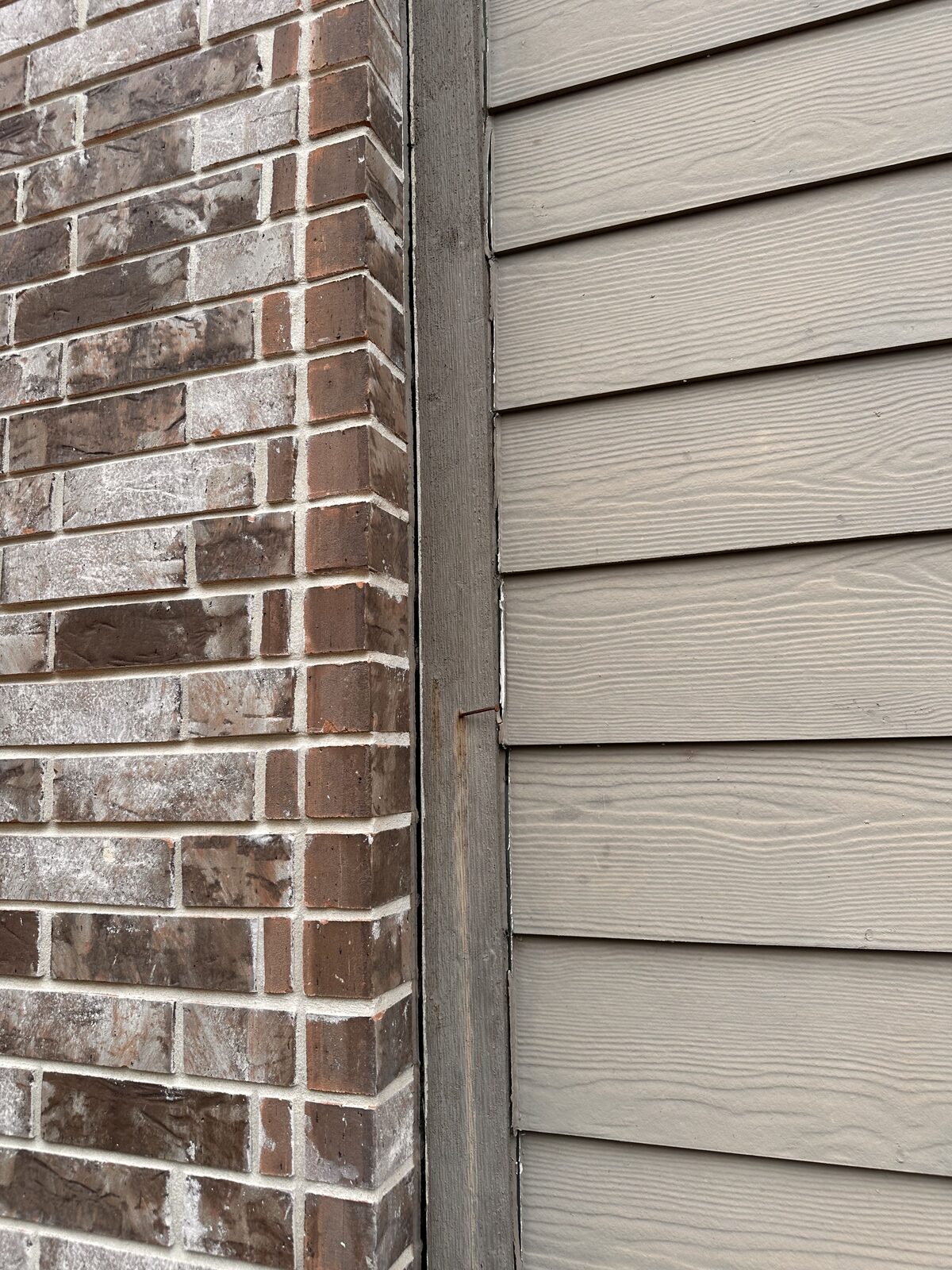 Gap between brick corner and siding trim on a Central Texas home