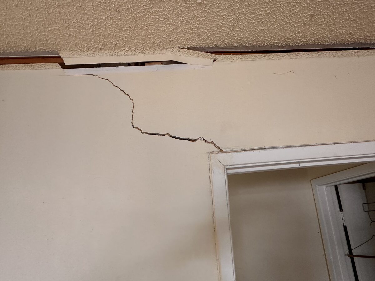 Long crack and trim separation above closet doors caused by foundation movement