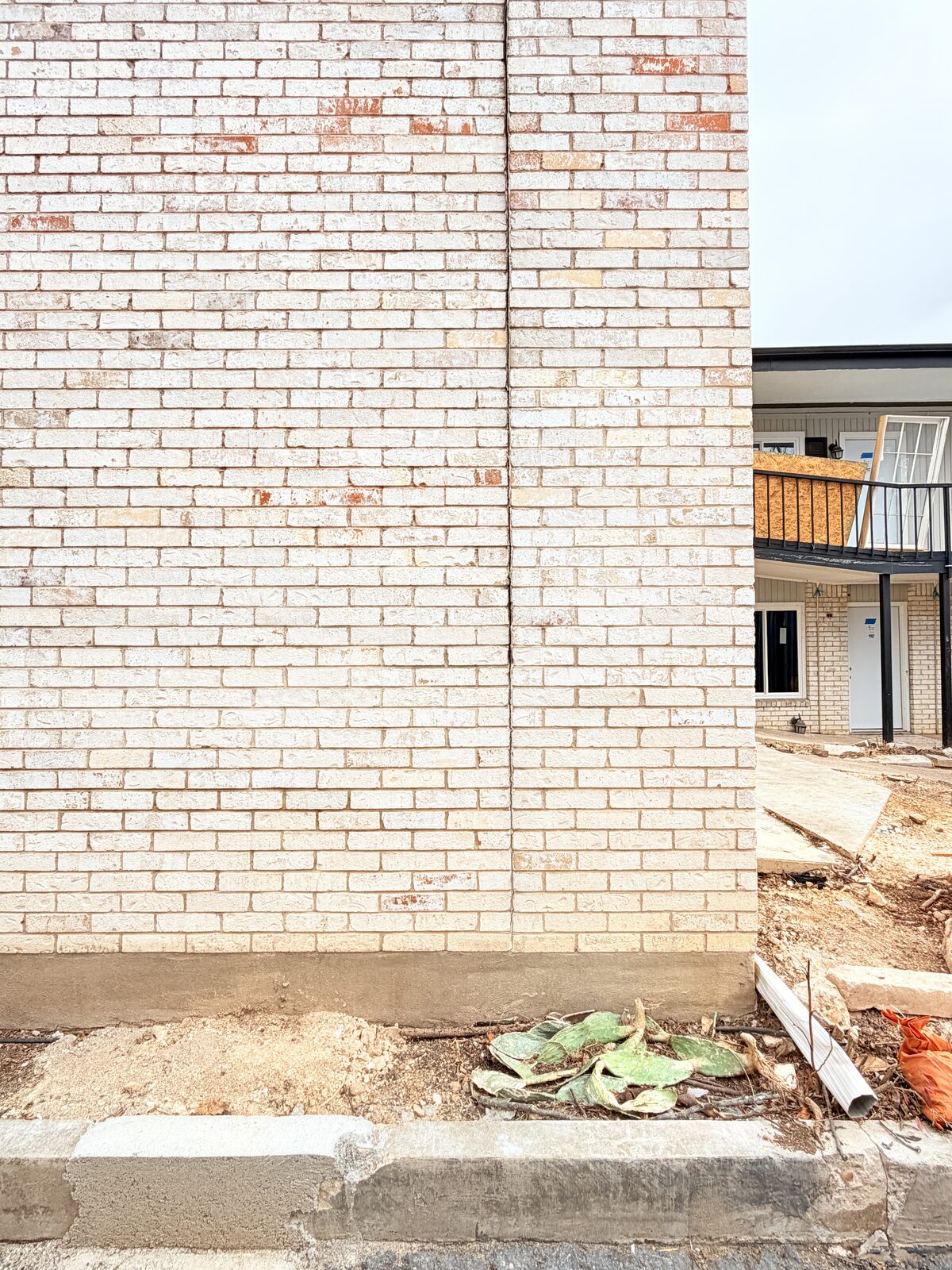 Vertical crack running down a brick wall on an active foundation repair site