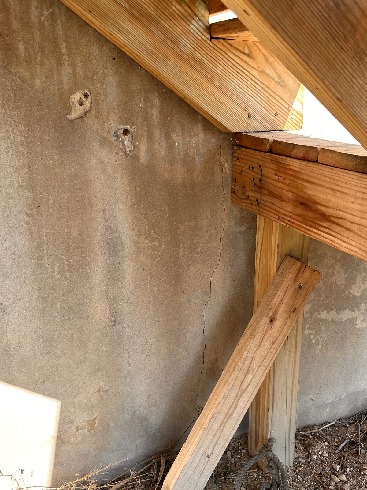 Wood framing and skirting at the raised foundation line of a pier and beam home during an inspection