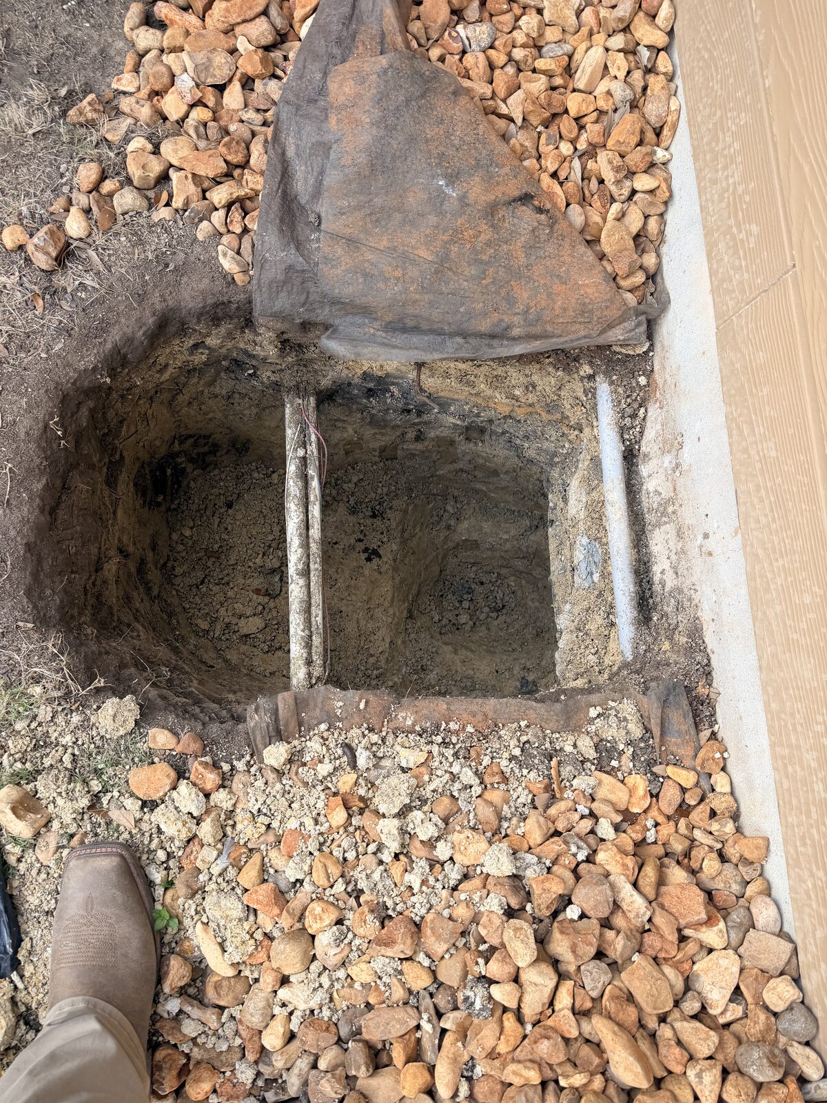 Deep pier pit excavated to expose the footing beneath a foundation before driving piers