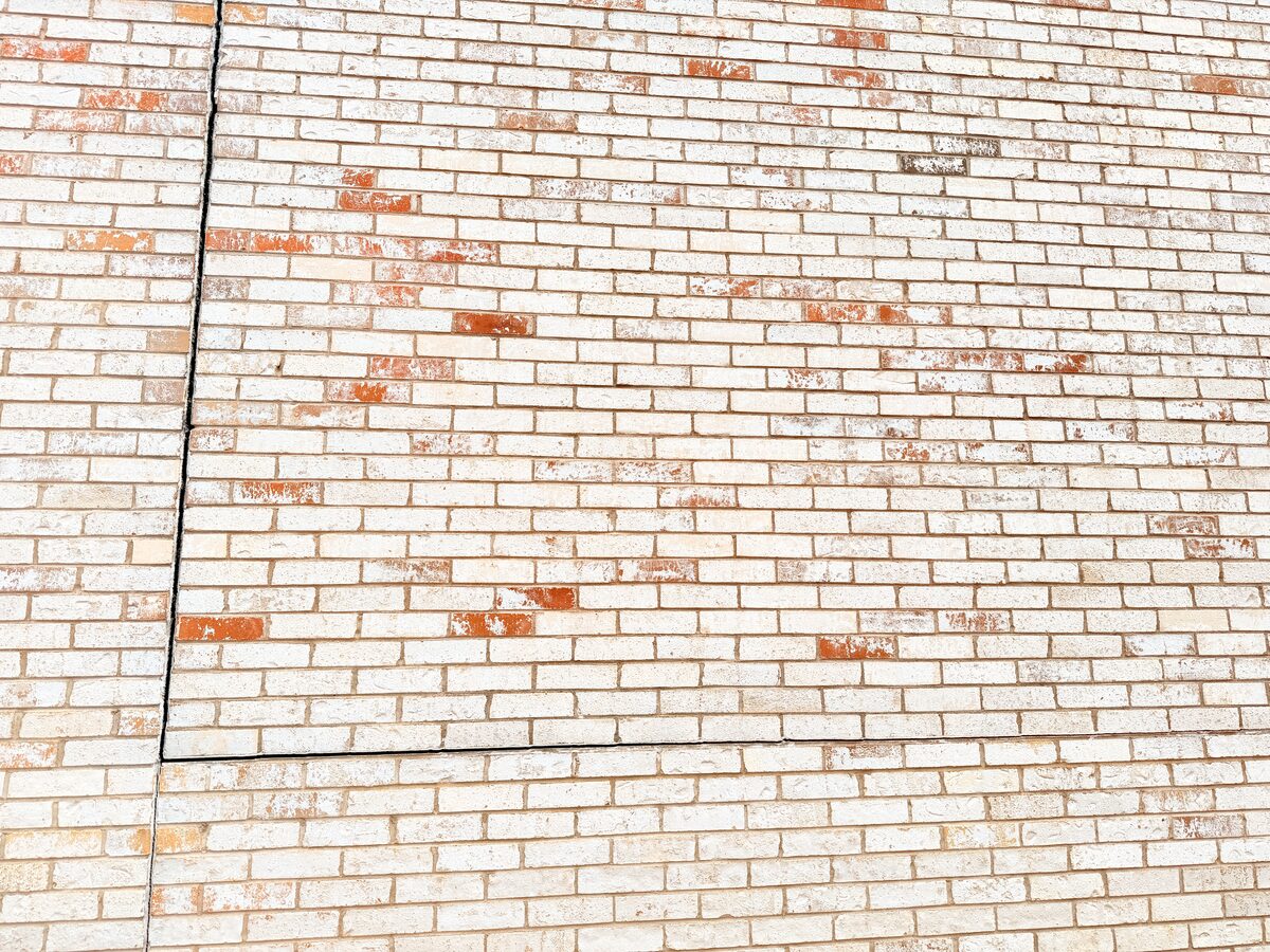Long diagonal crack line repointed across a brick wall, typical of differential foundation settlement