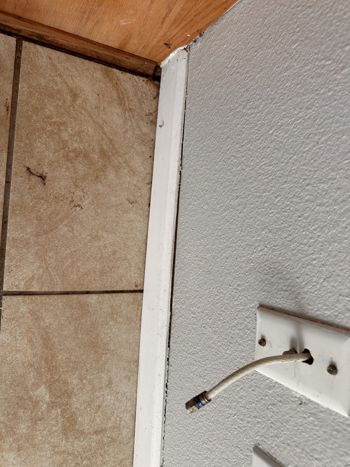 Door trim separating from the wall beside a tile floor as a slab foundation shifts