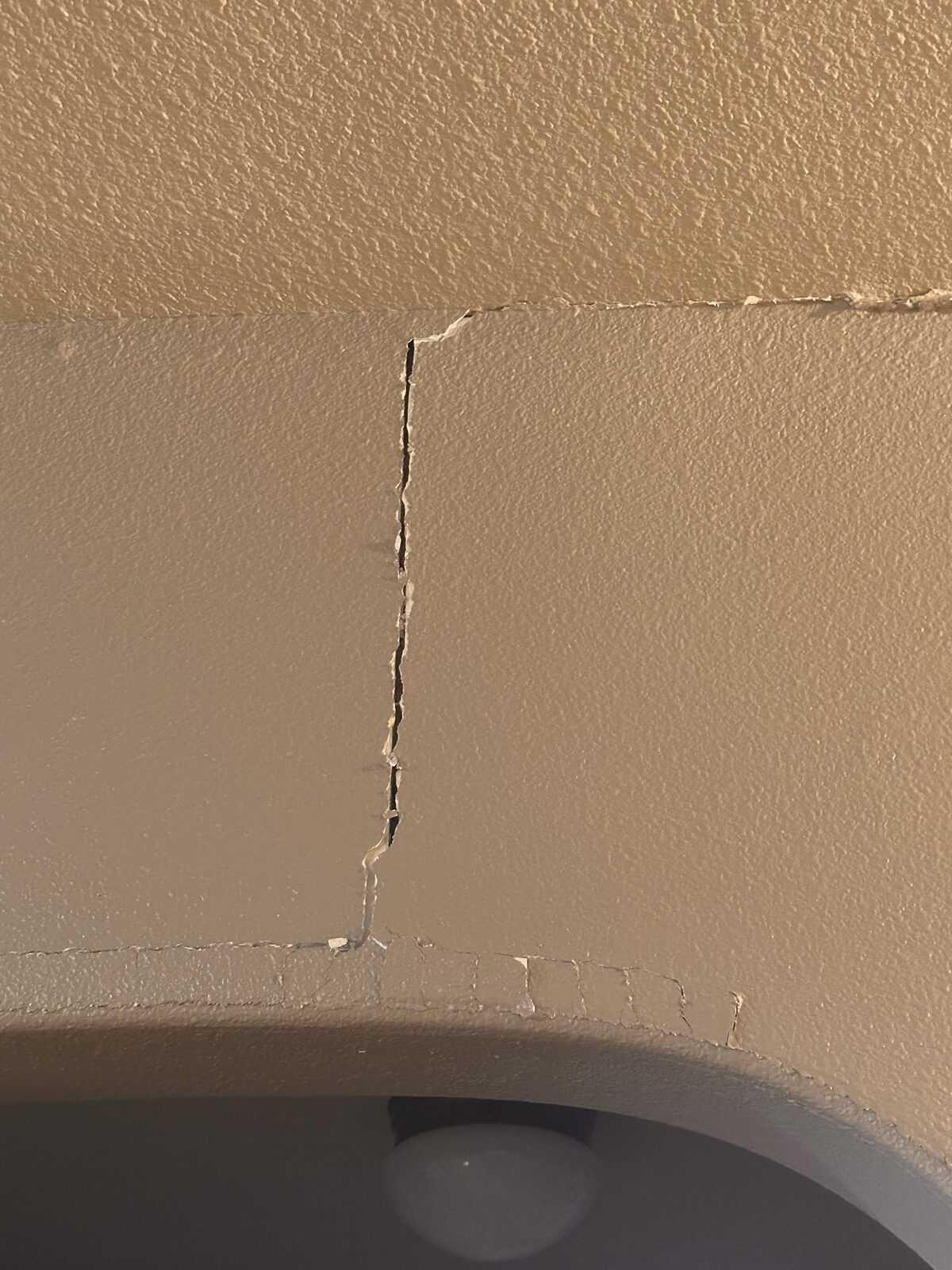 Vertical drywall crack above an interior archway, a common sign of foundation settlement