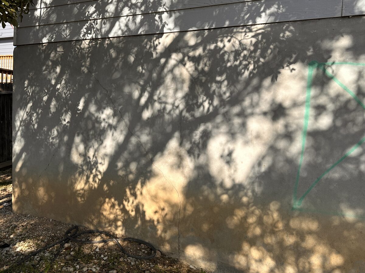 Foundation cracks circled in chalk on a stem wall during a professional inspection