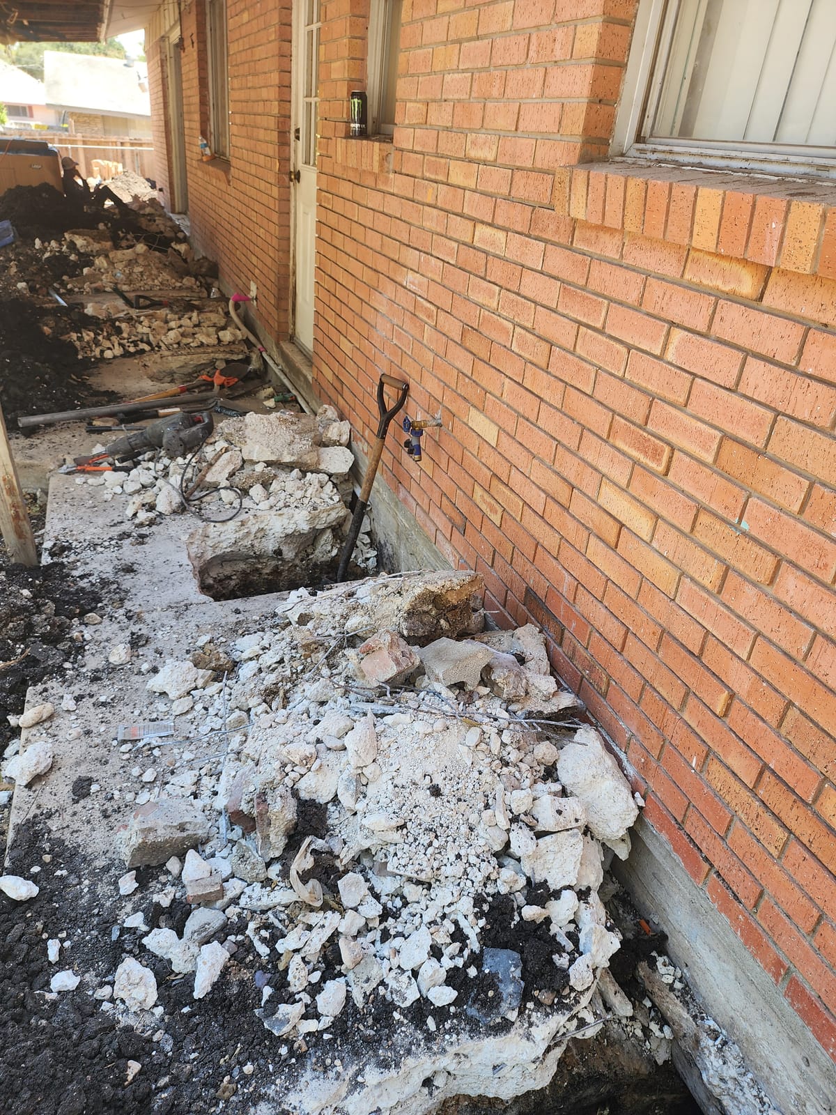 A completed Motmot foundation repair excavation on a Central Texas brick home, covered by the lifetime transferable warranty