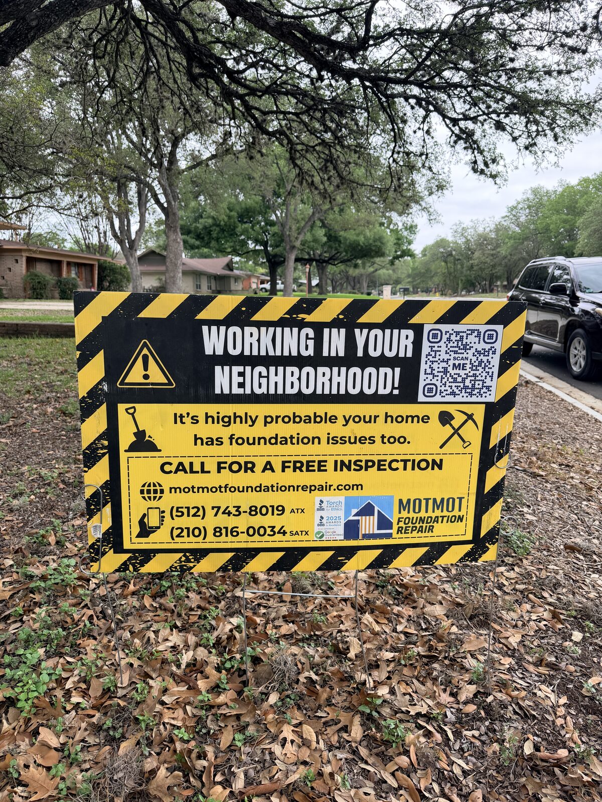 Close-up of a Motmot Foundation Repair yard sign offering a free foundation inspection