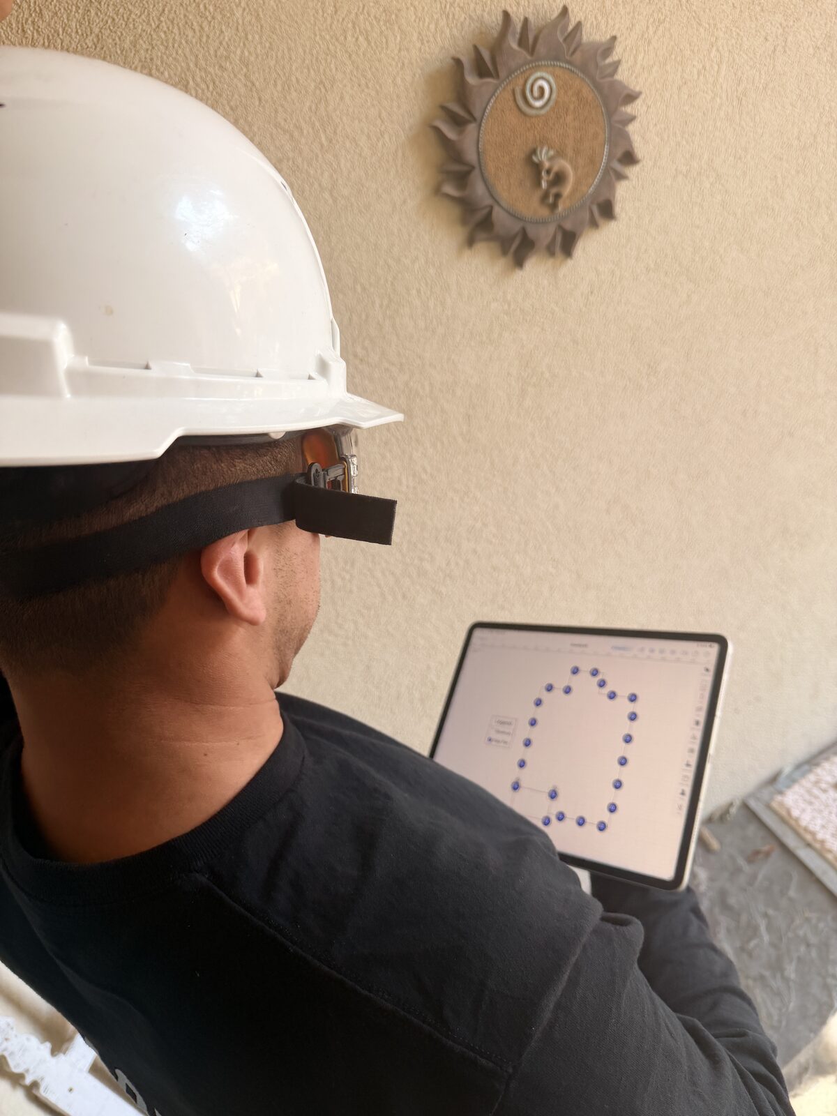 Inspector reviewing a color-coded floor elevation map on a tablet before planning a house leveling lift