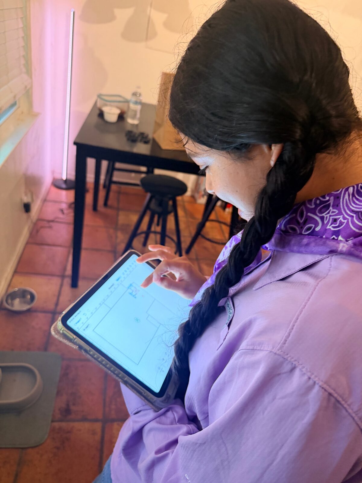 Inspector sketching a floor plan on a tablet in a tiled kitchen