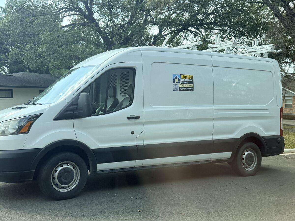 Motmot Foundation Repair service van parked at a residential job site