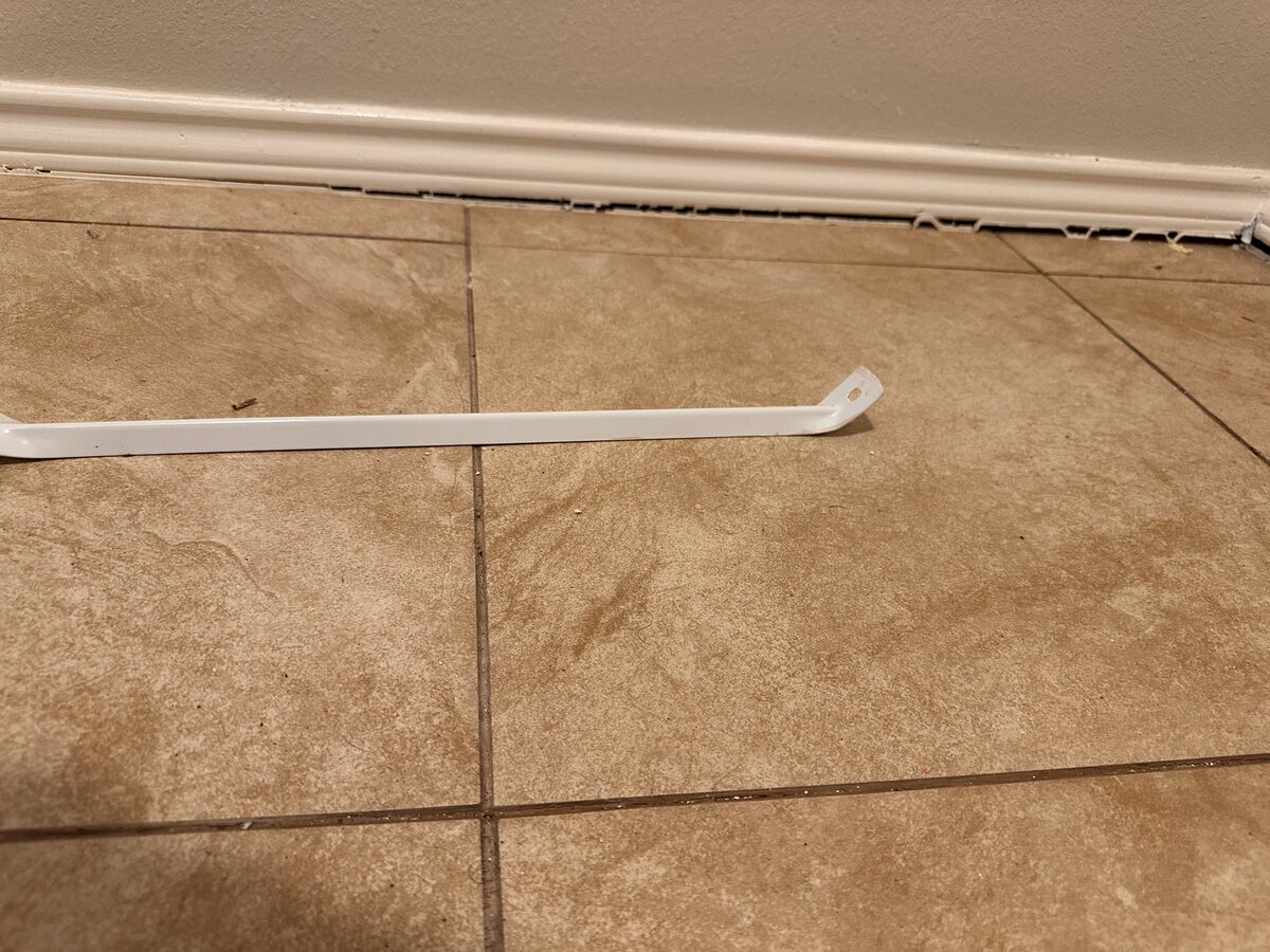 Shoe molding popped loose and lying on the tile floor where the baseboard separated during slab settlement
