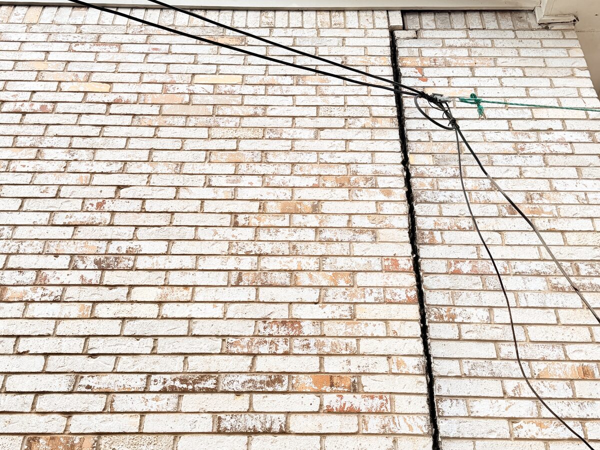 Replacement bricks set along a former stair-step crack in a wall repaired after foundation leveling