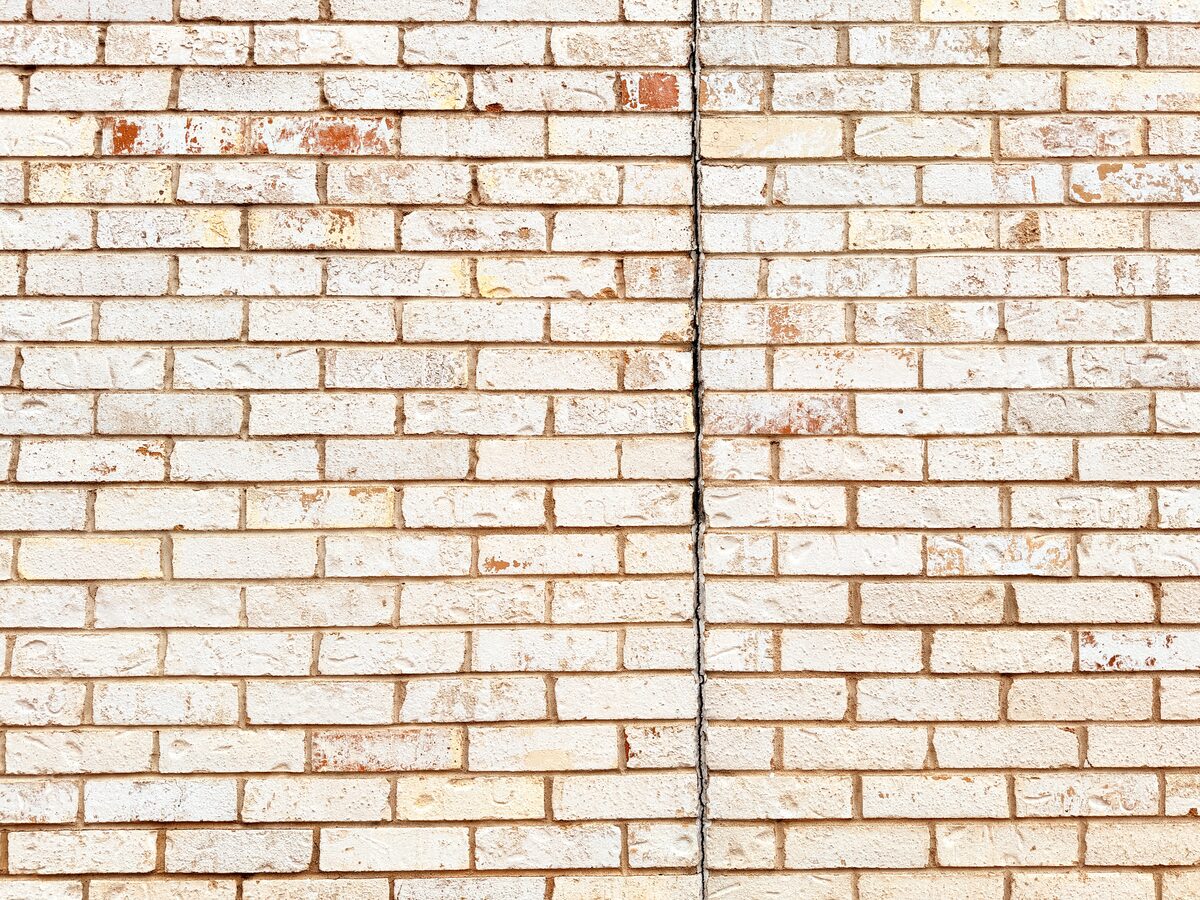 Closeup of a freshly repointed mortar joint in painted brick following foundation repair