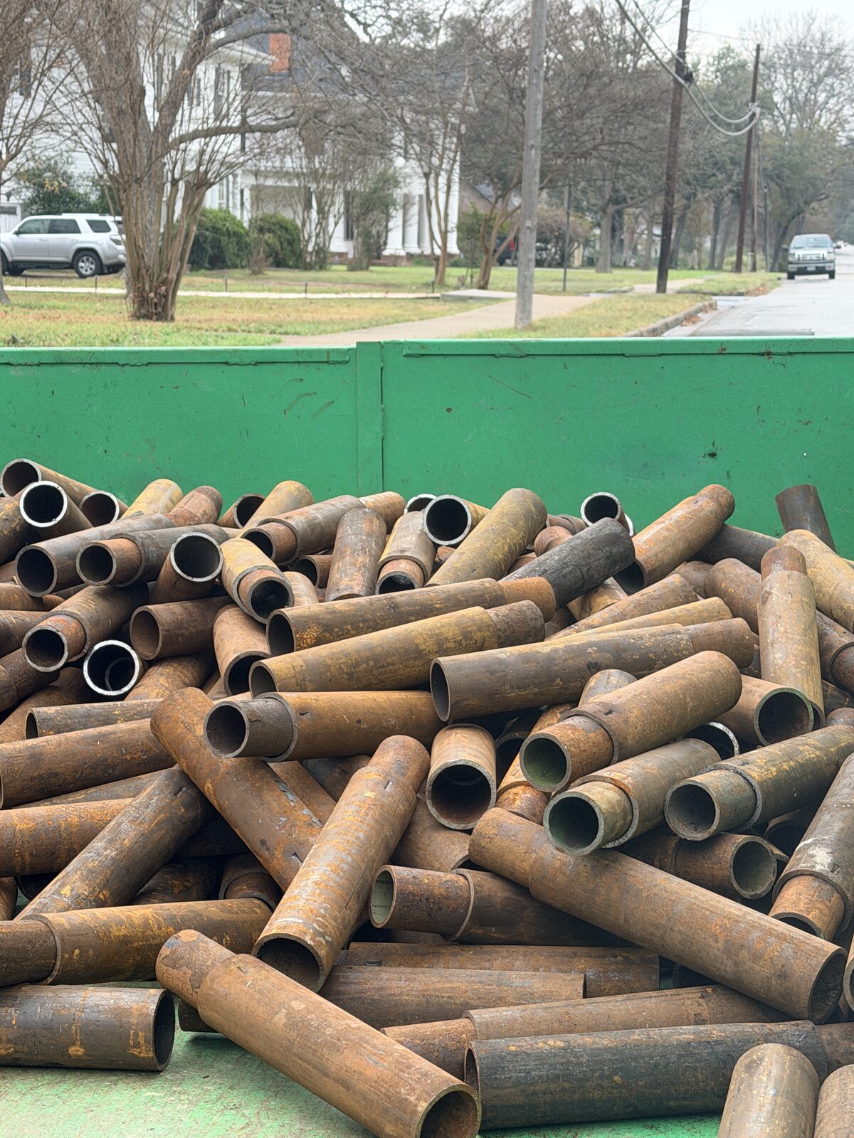 Close-up of stacked steel pier pipe sections staged for a foundation repair