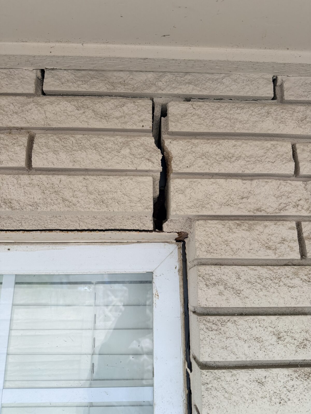 Stone courses separated and shifted out of line above a window opening