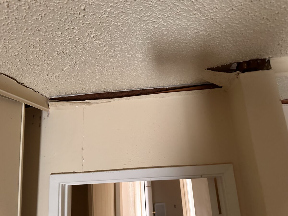 Separation along a vaulted ceiling corner above a doorway in a home with foundation movement