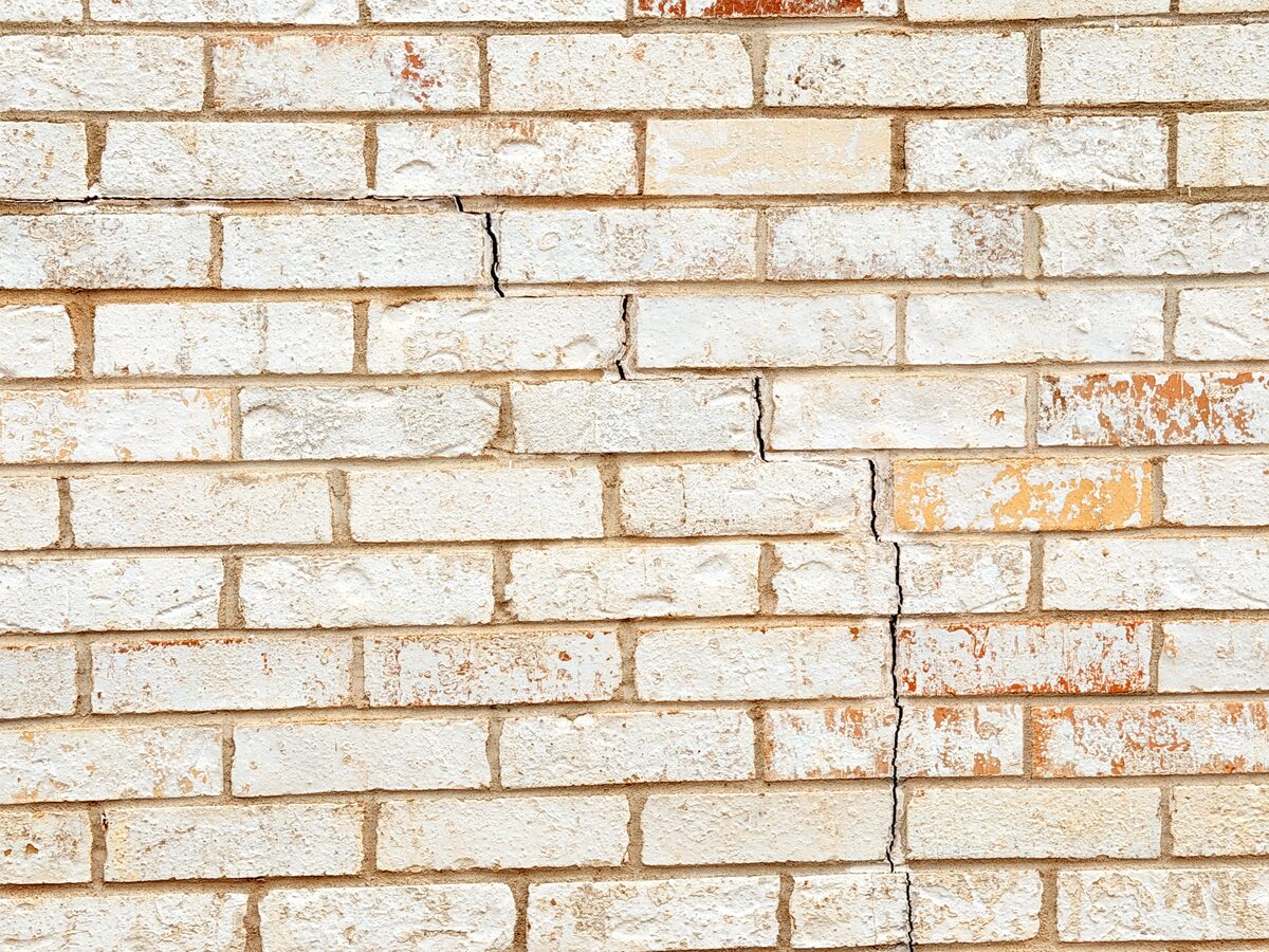 Closeup of a vertical crack breaking through brick faces, indicating significant foundation movement
