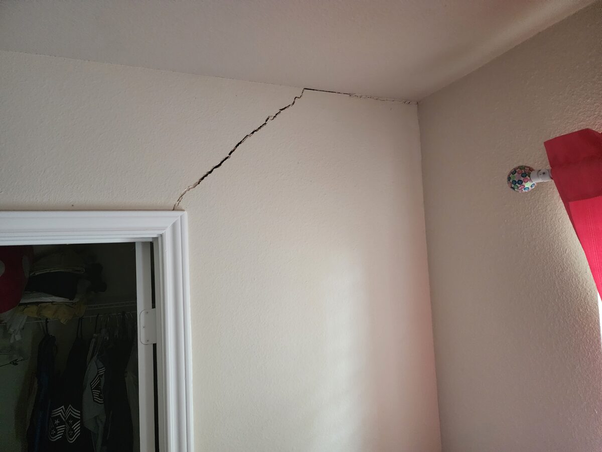 Diagonal crack at the wall and ceiling corner above a closet door, flagged during a foundation inspection